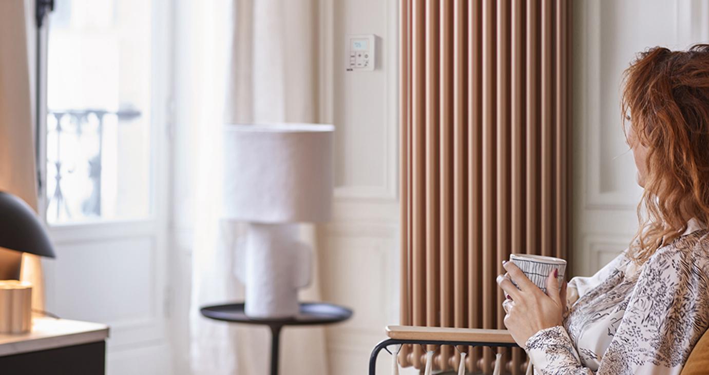 Femme assise confortablement près de son radiateur Vuelta