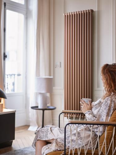 Femme assise confortablement près de son radiateur Vuelta